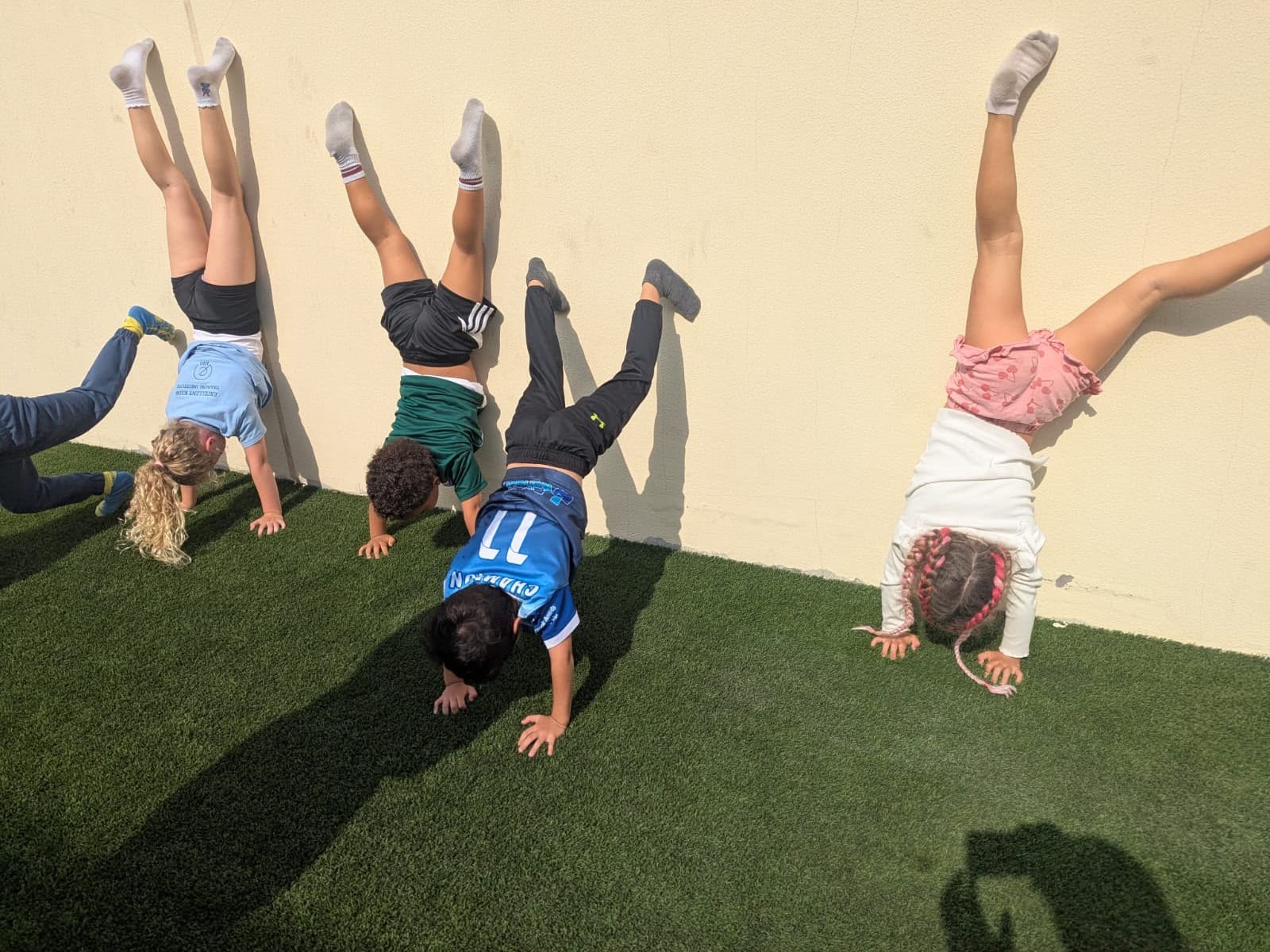 Children practising wall handstands during a Wolf Kids gymnastics session